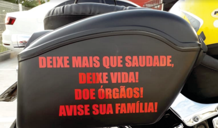 Frases de estímulo à doação de órgãos nos alforges da motocicleta de João Carlos